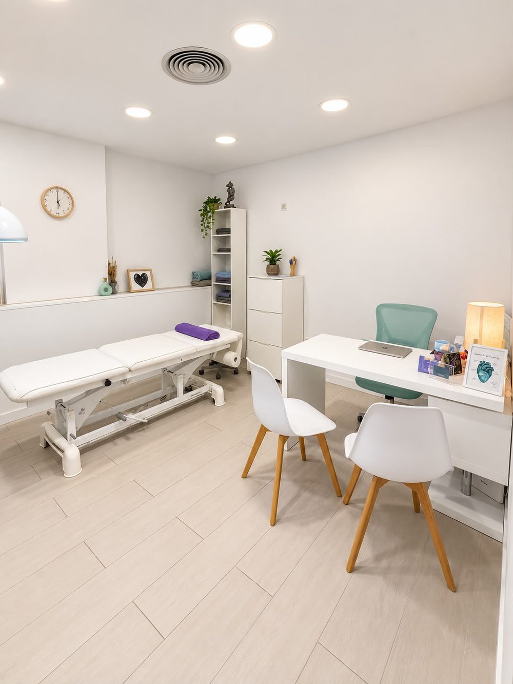 Sala de tratamiento con camilla eléctrica blanca, escritorio y dos sillas